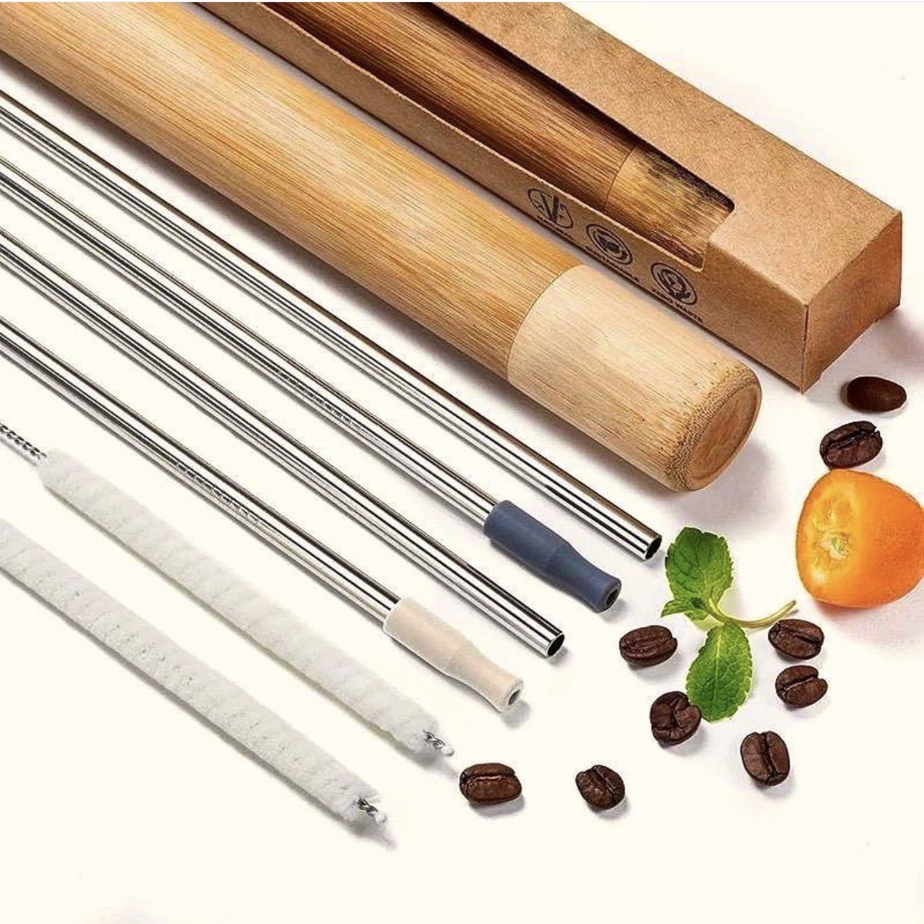 The Down2Earth kit laid out: polished stainless steel straws with silicone tips, two cleaning brushes, a bamboo travel case and its kraft box